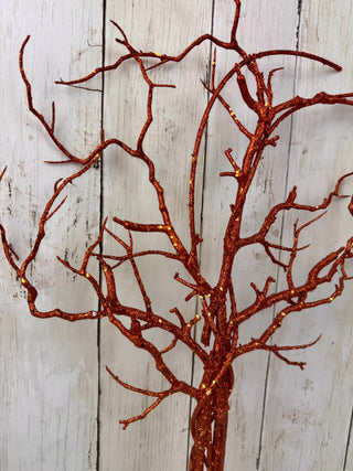 Decorative copper tree branch against a wooden background