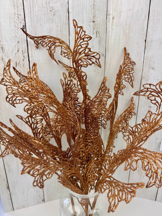 Decorative gold leaf branch against a wooden background