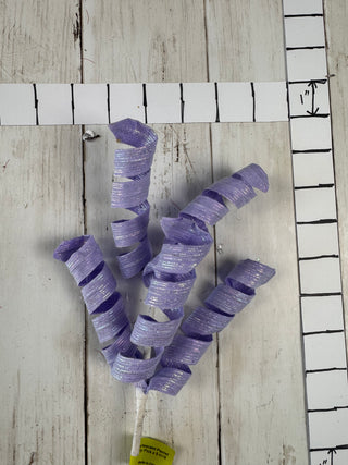 Purple ribbons on a wooden surface with a ruler in the background