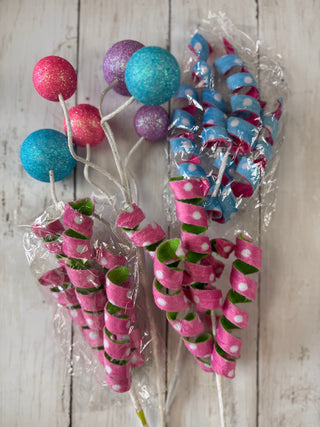 Decorative sticks with colorful spherical ends on a wooden surface
